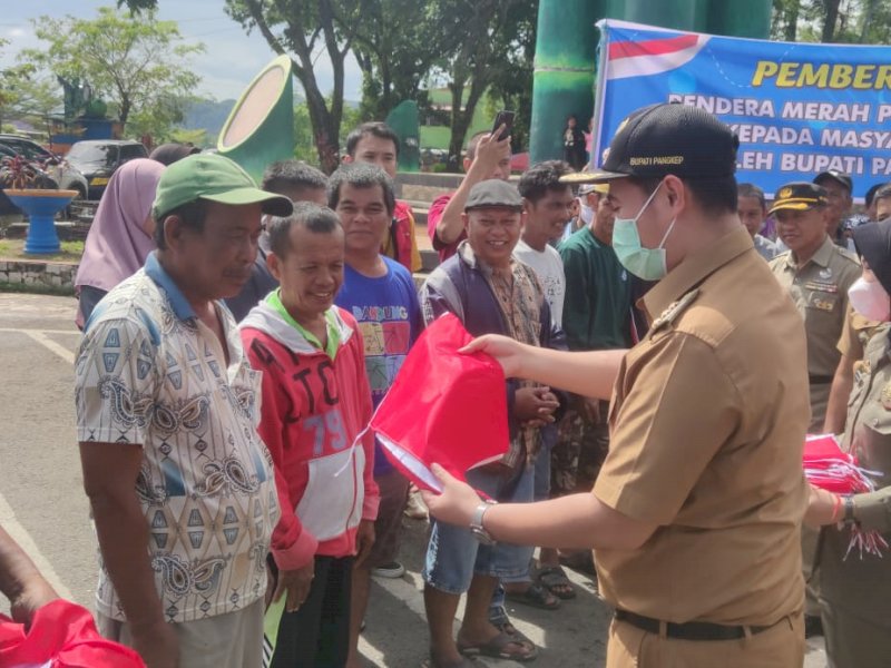 Bupati Pangkep Yusran Lalogau membagikan 176 bendera merah putih kepada masyarakat di Tugu Bambu Runcing, Senin (01/08/2022).