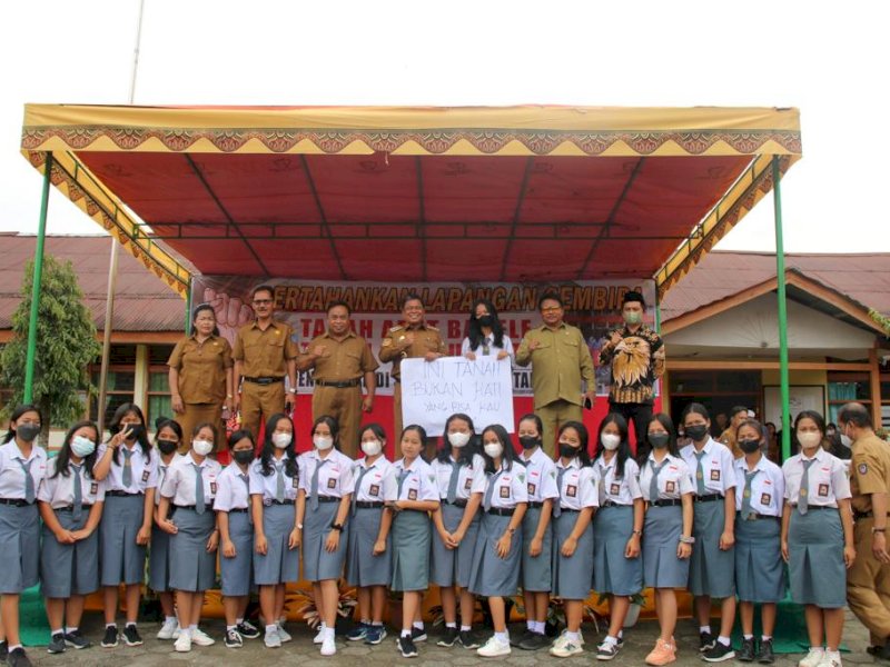 Bupati Torut Yohanis Bassang menunjukkan alas hak kepemilikan lahan SMAN 2 torut di hadapan siswa dan guru di Lapangan Gembira. 