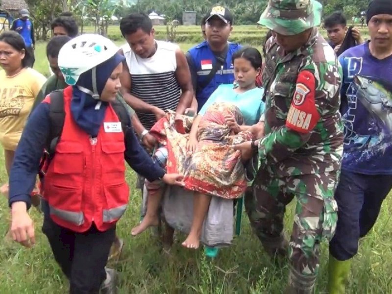Babinsa dan relawan PMI berjibaku menandu seorang ibu yang hendak melahirkan.