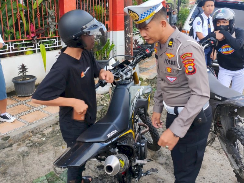 Seorang pengendara terjarinh razia karena menggunakan knalpot bising.