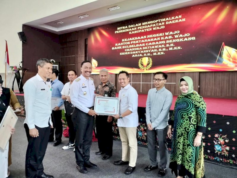 Wakil Bupati Wajo Amran menyerahkan penghargaan kepada pengelola Pajak Bumi dan Bangunan Perdesaan dan Perkotaan (PBB-P2).
