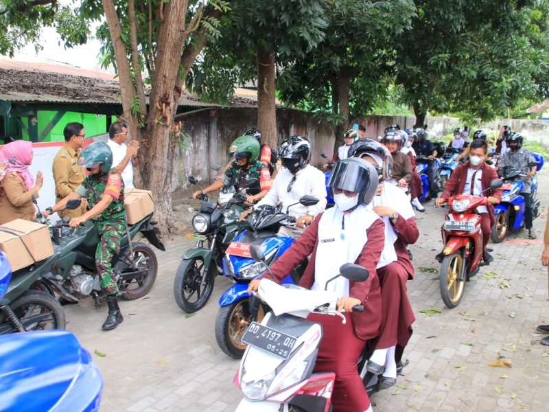 Aksi parade motor mendistribusikan paket gizi ke rumah rumah warga.

