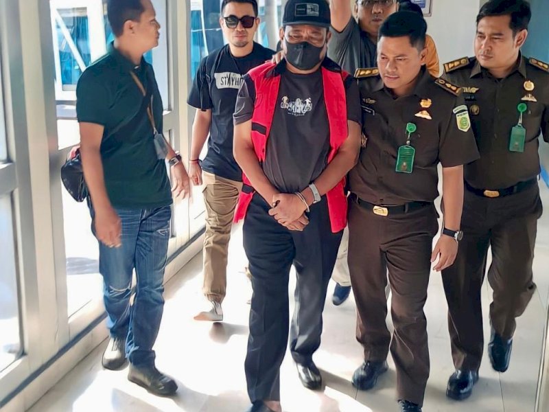Buronan korupsi Boni Tabrani Bin Sastra Prana diapit petugas. 