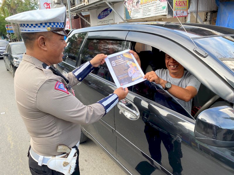 Satlantas Polres Wajo membagikan brosur kepada pengguna jalan. 