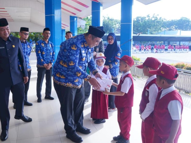 Bupati Maros Chaidir Syam membagikan seragam sekolah kepada siswa SD dan SMP. 