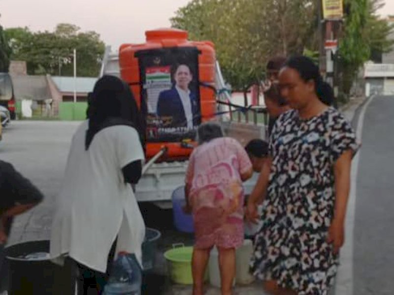 Warga menerima distribusi air bersih dari Anggota DPRD Makassar Supratman. 
