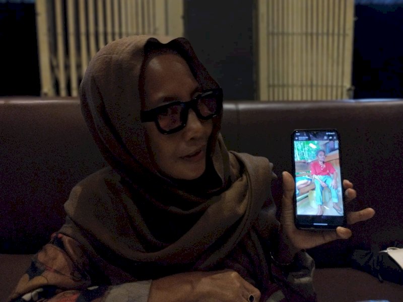 Indo Itte yang menunjukkan foto sang suami Basri Hajar di handphonenya saat ditemui awak media di salah satu kafe di Kota Makassar, Sulsel. (PEDOMAN MEDIA/Aldi) 