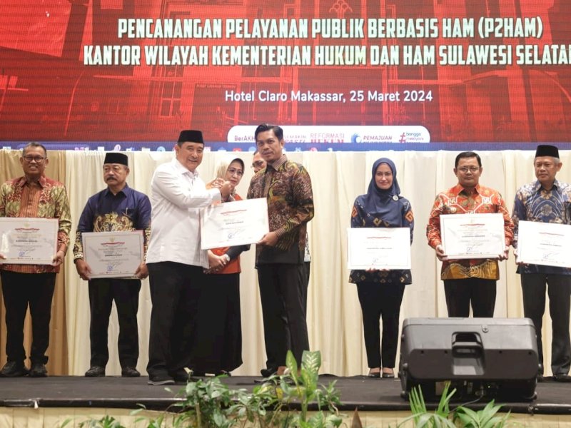 Pj Gubernur Sulsel Bachtiar Baharuddin menyerahkan pengharagaan HAM kepada Pj Sekda Kota Makassar Firman Hamid Pagarra. 