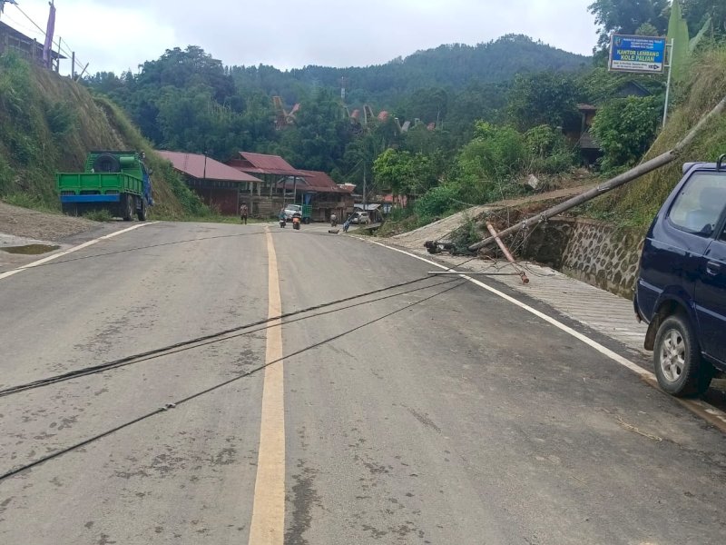 Kabel listrik yang menjuntai menyentuh permukaan jalan. 