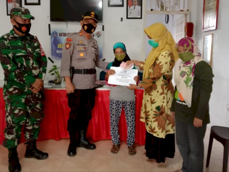 Kapolsek Ulaweng memantau penyaluran BLT di Desa Uci Bone. 