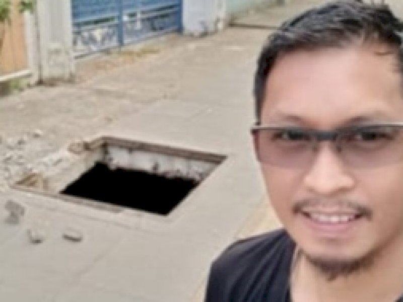 Humas Dinas PU Makassar Hamka Darwis saat meninjau penutup drainase yang hilang di Hertasning. 