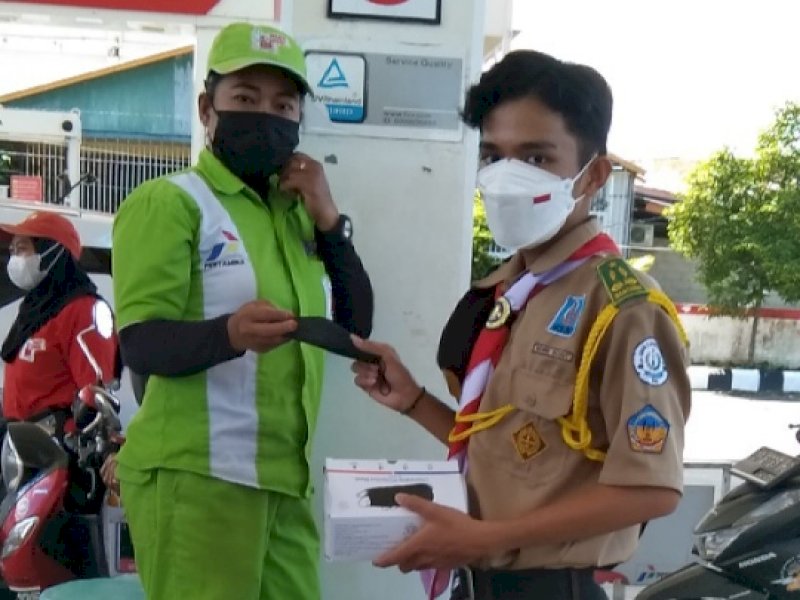Pramuka Kwarcab Lutra saat membagikan masker ke warga. 