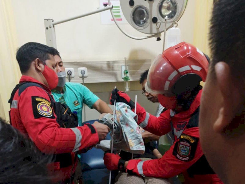 Petugas pemadam kebakaran Kota Makassar memotong besi di tangan warga Makassar. Saat asyik main tiktok. (Foto: Ist)