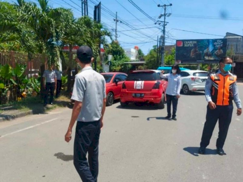 Petugas Dishub Kota Makassar melakukan penertiban kendaraan yang parkir dibahu jalan. (Ist)