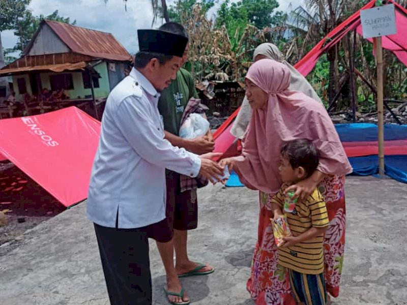 Kepala KUA Bontoramba Kabupaten Jeneponto Sahani bersama staf memberikan bantuan kepada korban musibah kebakaran di Tangkulu. (Ist)