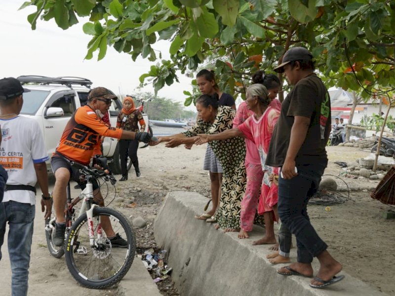 Bupati Bulukumba Andi Utta menyapa warga sambil sedekah di Pantai Merpati. (Ist)
