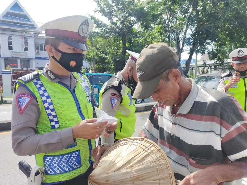 Personel Sat Lantas Polres Takalar bagikan masker bagi pengguna jalan. (Ist)