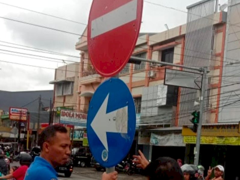 Petugas Dishub Makassar memasang rambu jalan. (Ist)