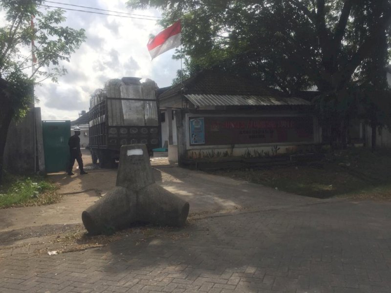 Pemasangan batu beton di depan pintu pabrik. (Ist)