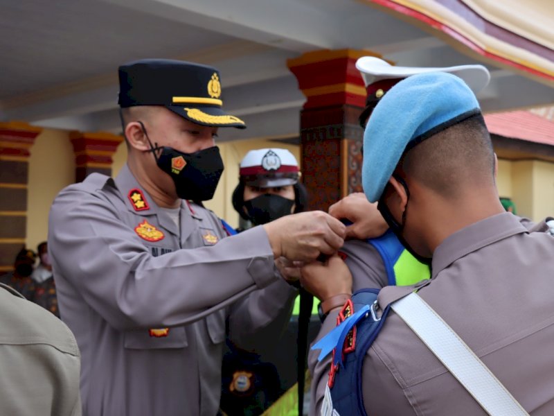 Kapolres Tator AKBP Juara Silalahi menyempatkan pita kepada salah seorang personel Polres. (Ist)