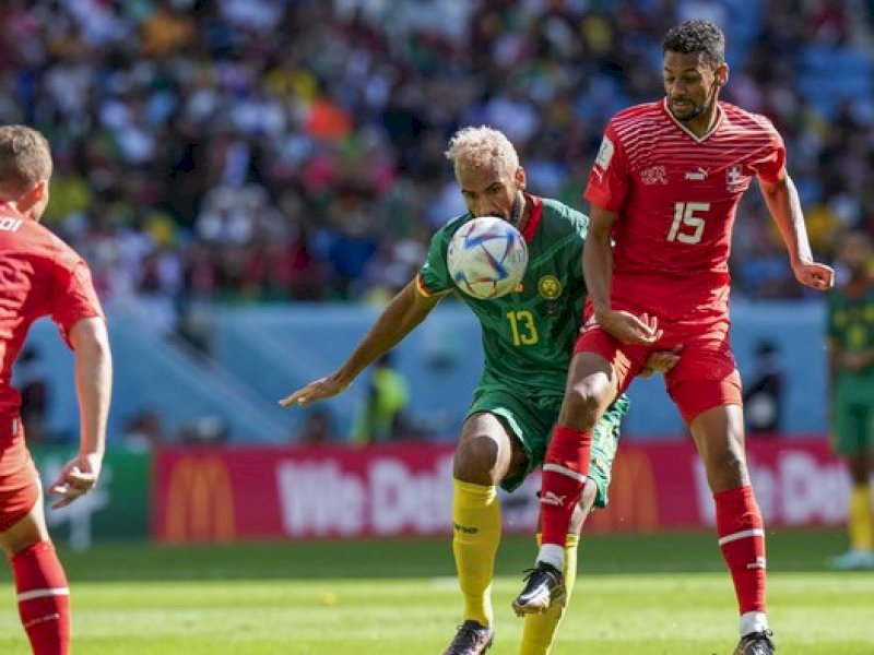 Pemain Swiss dan Kamerun berebut bola dalam laga petang tadi.