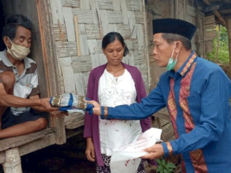 Yan Anggong Kalalembang saat menyerahkan bantuan.